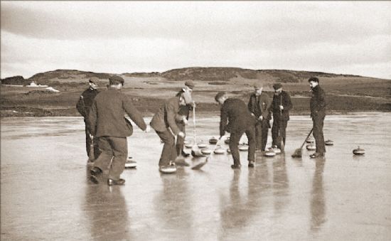 Black and white photograph of men dressed in tweeds and bunnets having a game of curling on a frozen pond.